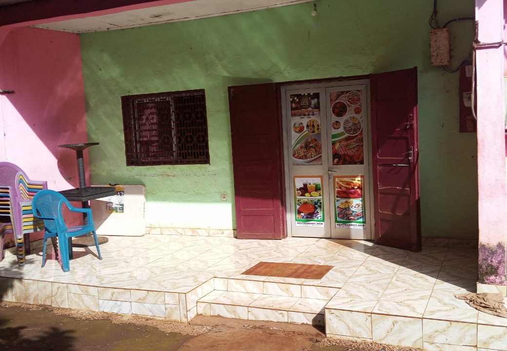 La véritable entrée de Coin Chaleureux : façade verte, terrasse et porte vitrée